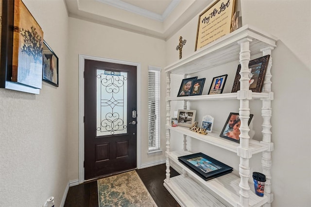 foyer featuring ornamental molding, dark wood finished floors, and baseboards