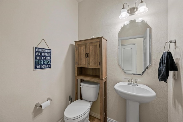 bathroom featuring toilet and baseboards