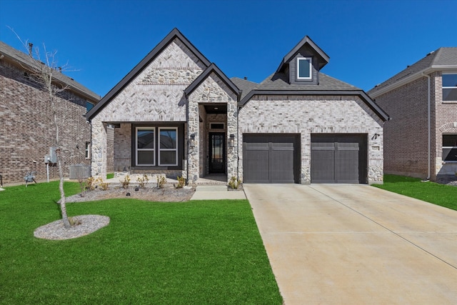 french country home with a garage, driveway, brick siding, and a front yard