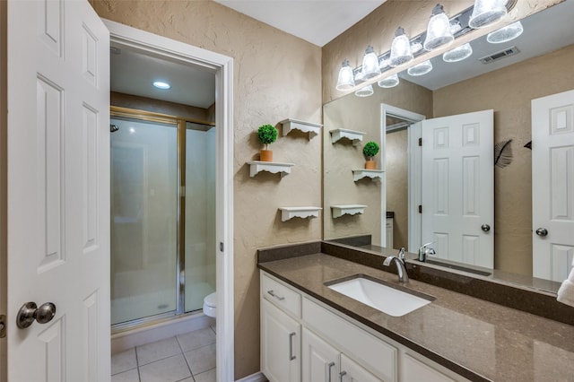 bathroom with visible vents, toilet, a shower stall, vanity, and tile patterned floors