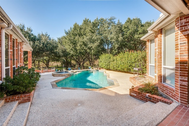 view of swimming pool featuring a pool with connected hot tub and a patio