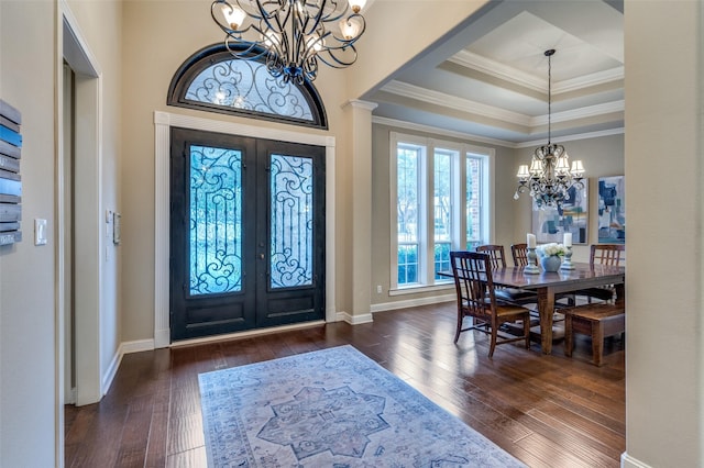 entryway with an inviting chandelier, wood-type flooring, crown molding, and french doors