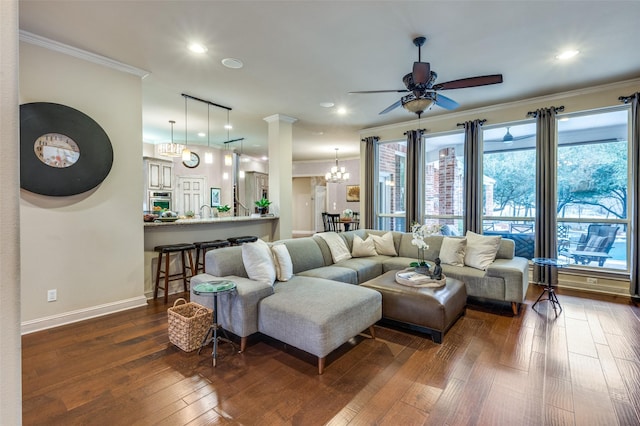 living room with dark wood-style flooring, crown molding, recessed lighting, baseboards, and ceiling fan with notable chandelier