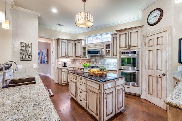 kitchen featuring stainless steel appliances, visible vents, dark wood-type flooring, a sink, and light stone countertops