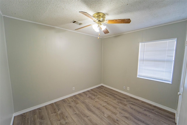 spare room with visible vents, ceiling fan, a textured ceiling, and wood finished floors