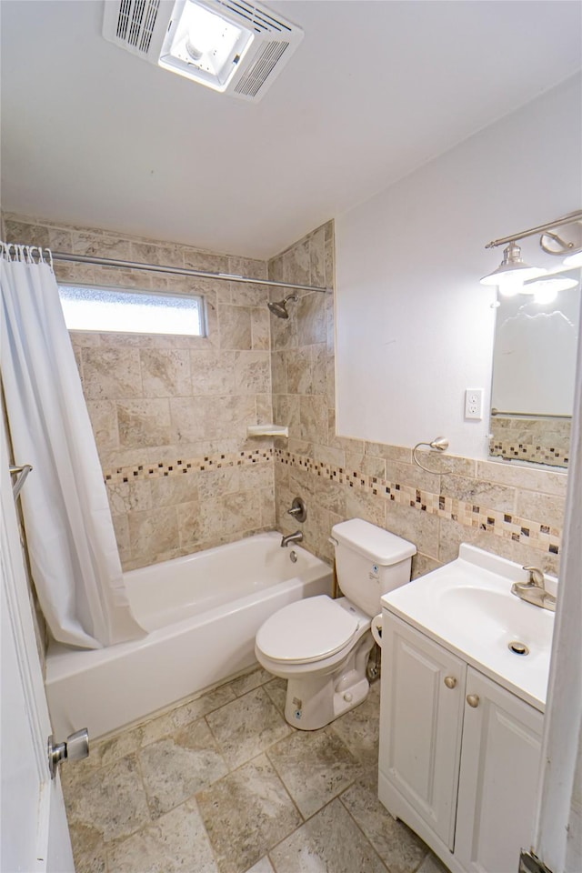 full bath featuring visible vents, toilet, shower / bathtub combination with curtain, vanity, and tile walls