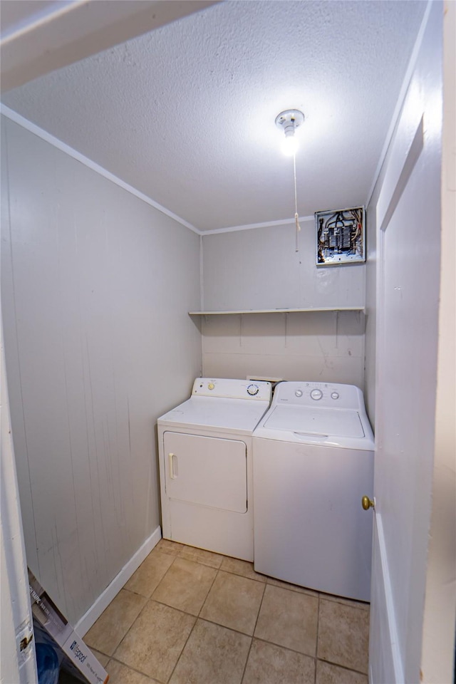 clothes washing area with a textured ceiling, laundry area, light tile patterned flooring, and washing machine and clothes dryer