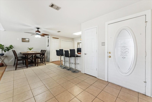 entryway featuring light tile patterned flooring, visible vents, and a ceiling fan