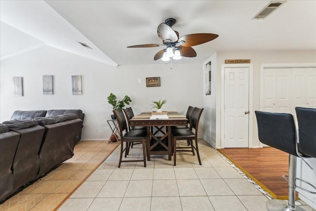 dining space with lofted ceiling, visible vents, a ceiling fan, and light tile patterned flooring