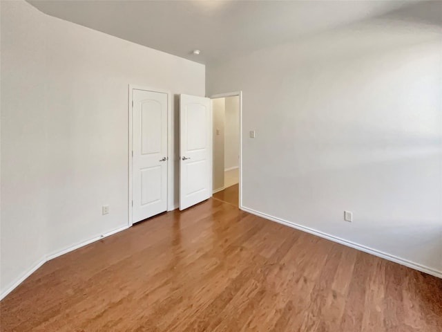 unfurnished bedroom with wood finished floors and baseboards