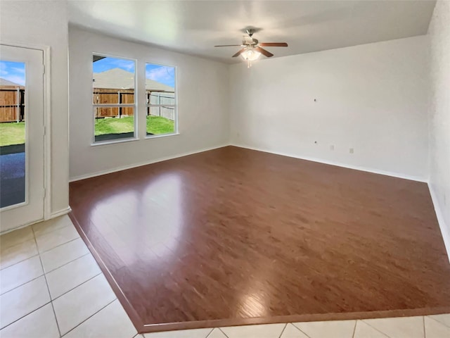 unfurnished room featuring ceiling fan, baseboards, and light tile patterned flooring