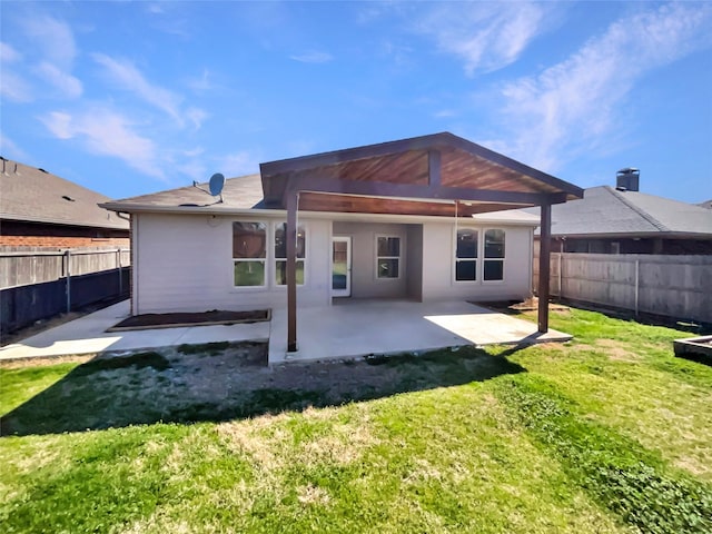 back of house featuring a yard, a patio area, and a fenced backyard