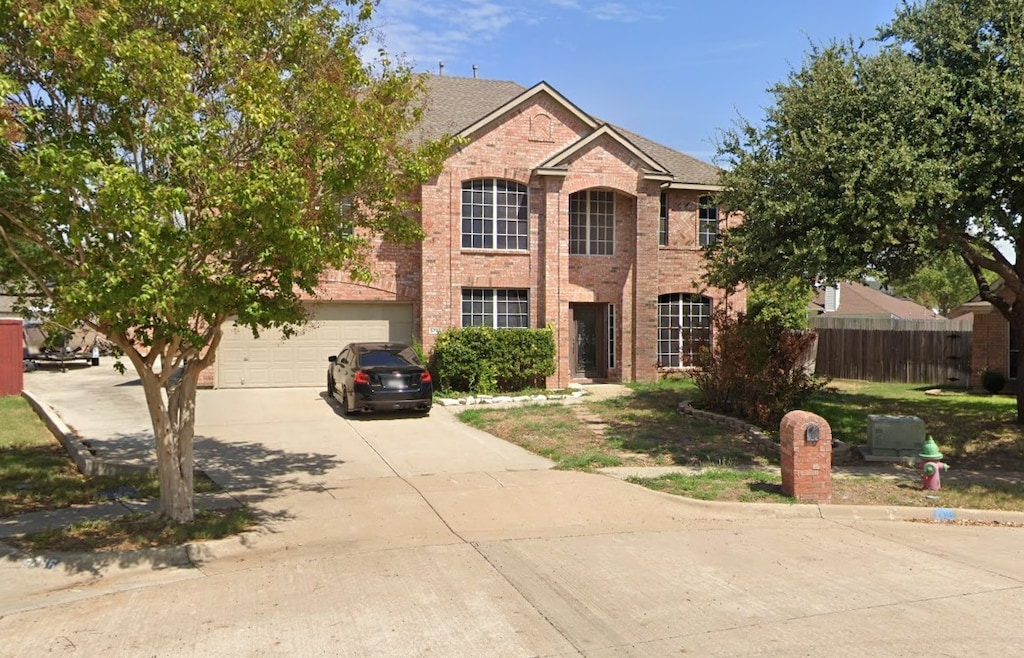 view of front of home featuring a garage, fence, concrete driveway, and brick siding