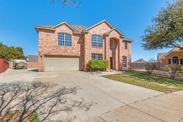 traditional-style house featuring a garage, concrete driveway, brick siding, and fence