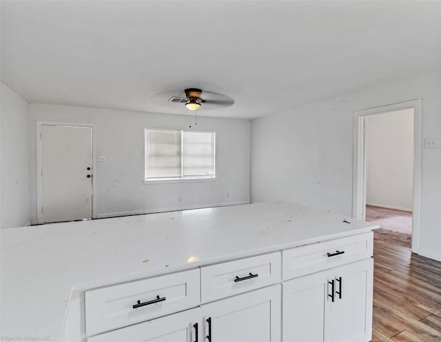 kitchen featuring baseboards, light wood-style flooring, white cabinetry, and ceiling fan