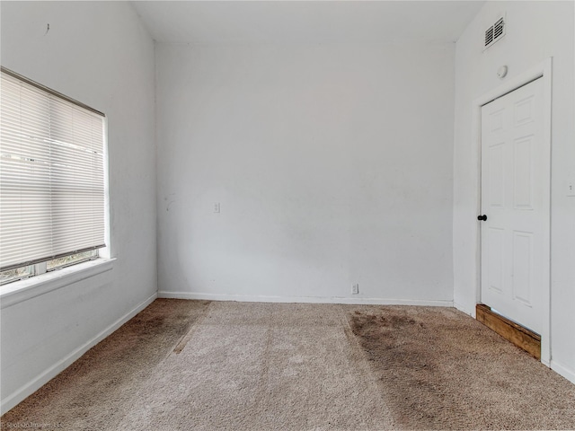 spare room with visible vents, baseboards, and carpet floors