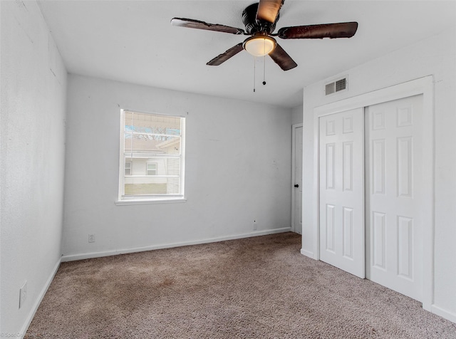 unfurnished bedroom with carpet, visible vents, a closet, and baseboards