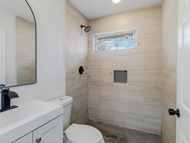 full bathroom featuring vanity, toilet, and tiled shower