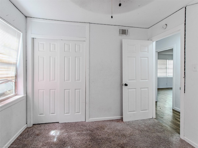 unfurnished bedroom featuring a closet, visible vents, and multiple windows