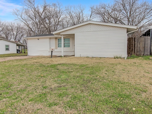 back of house featuring a lawn and fence