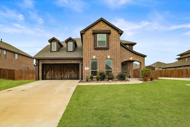 view of front facade with a front yard, concrete driveway, and brick siding