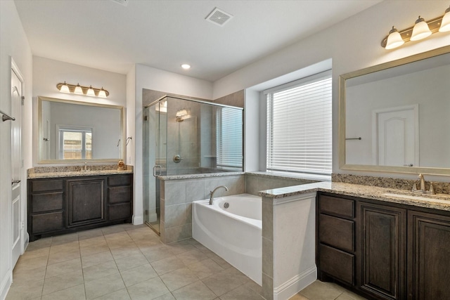 full bath featuring a shower stall, visible vents, two vanities, and a sink