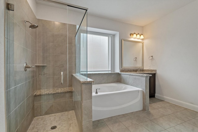 bathroom featuring baseboards, tile patterned flooring, vanity, a shower stall, and a bath