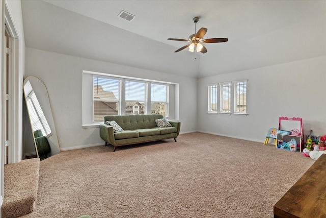 interior space with carpet, lofted ceiling, visible vents, a ceiling fan, and baseboards