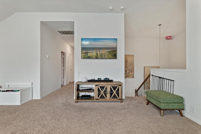 sitting room with carpet flooring, an upstairs landing, and visible vents