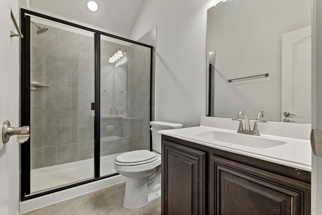 bathroom featuring toilet, vanity, a shower stall, and tile patterned floors