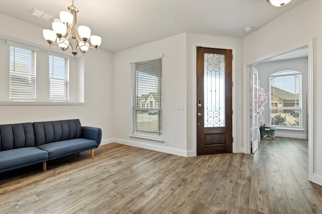 entryway with baseboards, wood finished floors, visible vents, and a healthy amount of sunlight