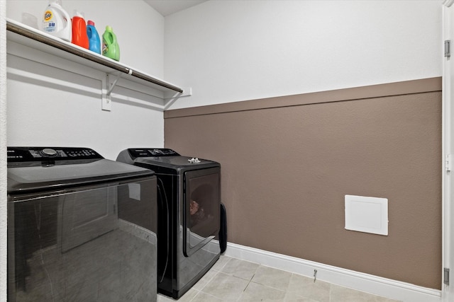 washroom featuring laundry area, light tile patterned flooring, baseboards, and separate washer and dryer