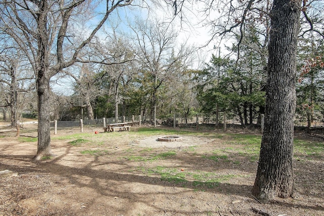 view of yard featuring an outdoor fire pit and fence