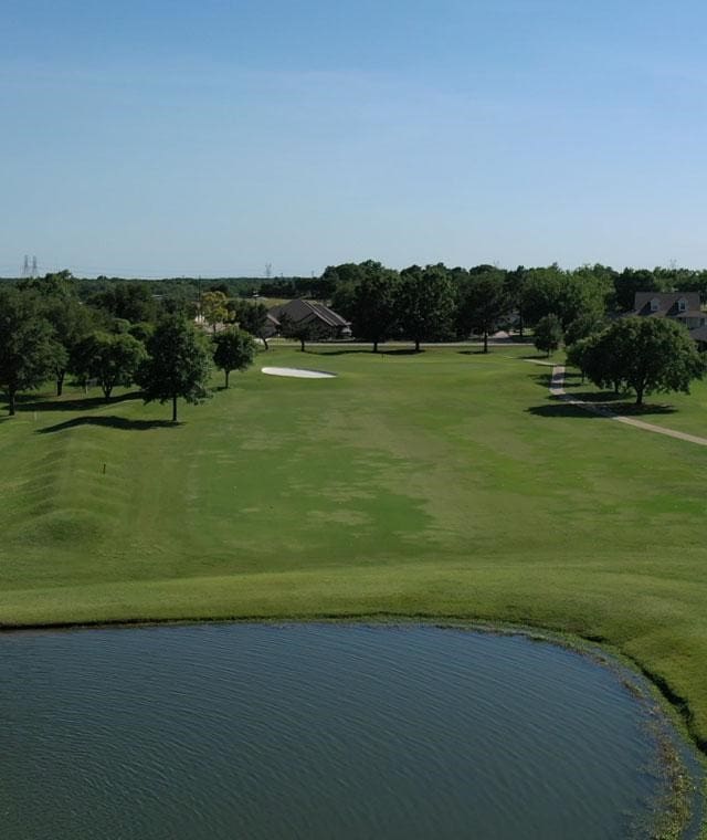 view of community with view of golf course, a water view, and a lawn