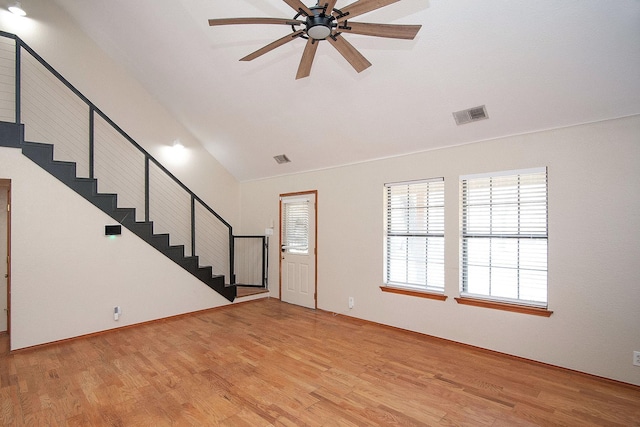 interior space featuring visible vents, a ceiling fan, lofted ceiling, stairs, and light wood-type flooring