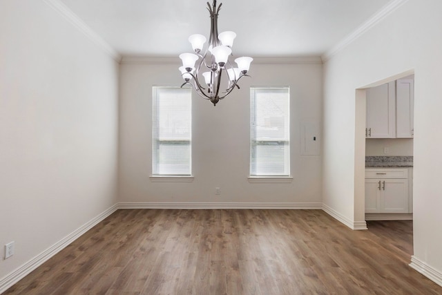 unfurnished dining area featuring a chandelier, dark wood finished floors, crown molding, and baseboards