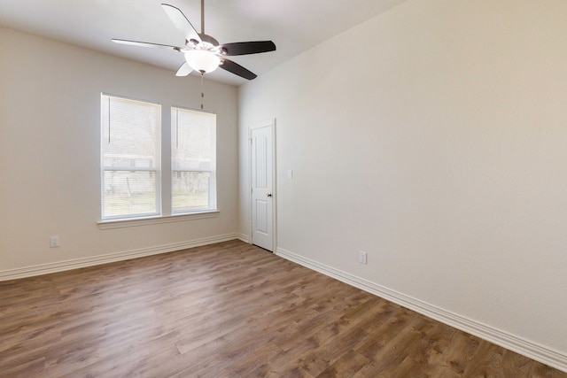 unfurnished room with a ceiling fan, baseboards, and wood finished floors