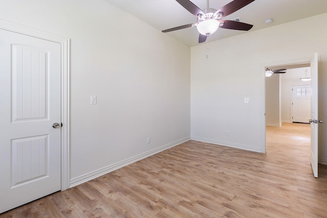 unfurnished room with light wood-style floors, baseboards, and a ceiling fan