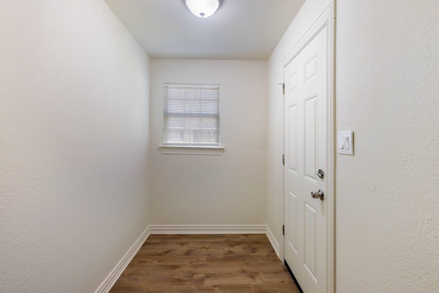 doorway to outside featuring wood finished floors and baseboards