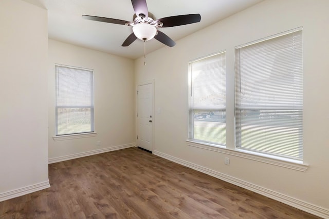 unfurnished room featuring ceiling fan, baseboards, and wood finished floors