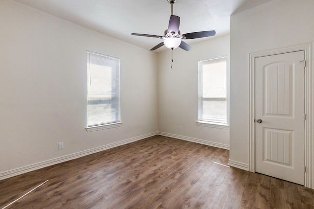 unfurnished bedroom featuring dark wood-style floors, multiple windows, and baseboards