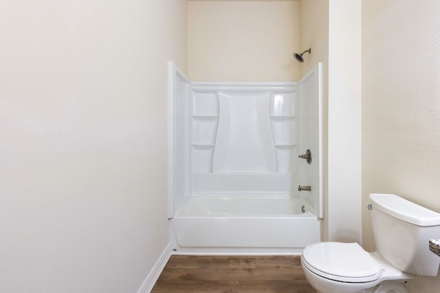 bathroom with toilet, wood finished floors, and shower / bathing tub combination