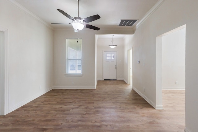 foyer featuring light wood-style flooring, visible vents, and crown molding