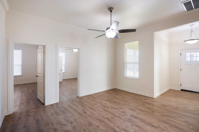 interior space featuring ornamental molding, visible vents, baseboards, and wood finished floors