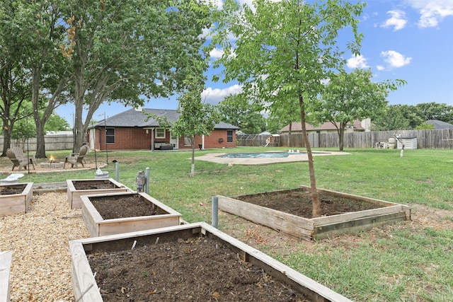 view of yard featuring a fenced in pool, a fenced backyard, and a vegetable garden