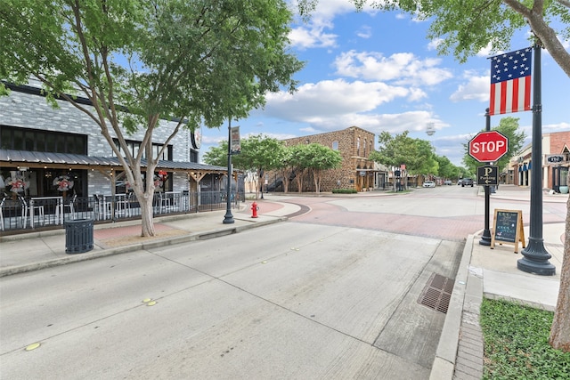 view of road featuring curbs, traffic signs, and sidewalks