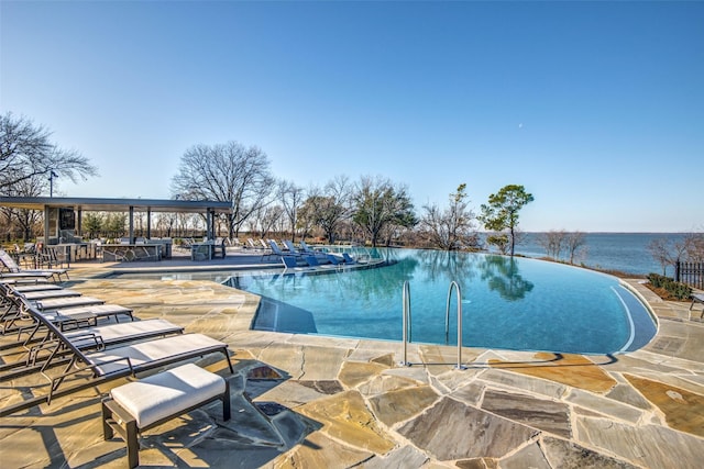 community pool with a water view and a patio