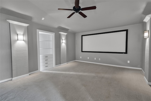 cinema featuring a ceiling fan, baseboards, built in features, and light colored carpet