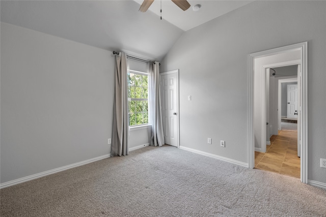 spare room with lofted ceiling, light carpet, ceiling fan, and baseboards