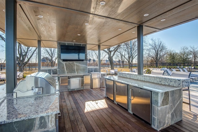 wooden deck featuring outdoor wet bar and area for grilling